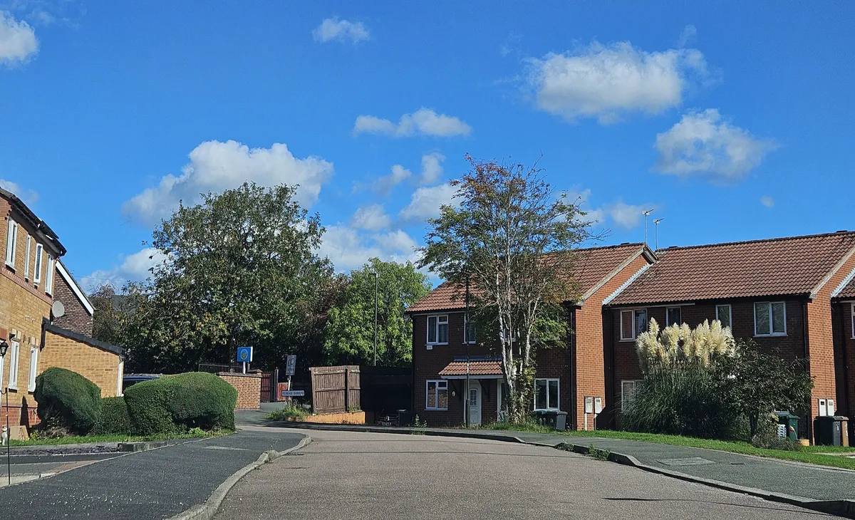 Red-brick semi-detached houses with tiled roofs and small front gardens on Vicarage Gardens in Swadlincote